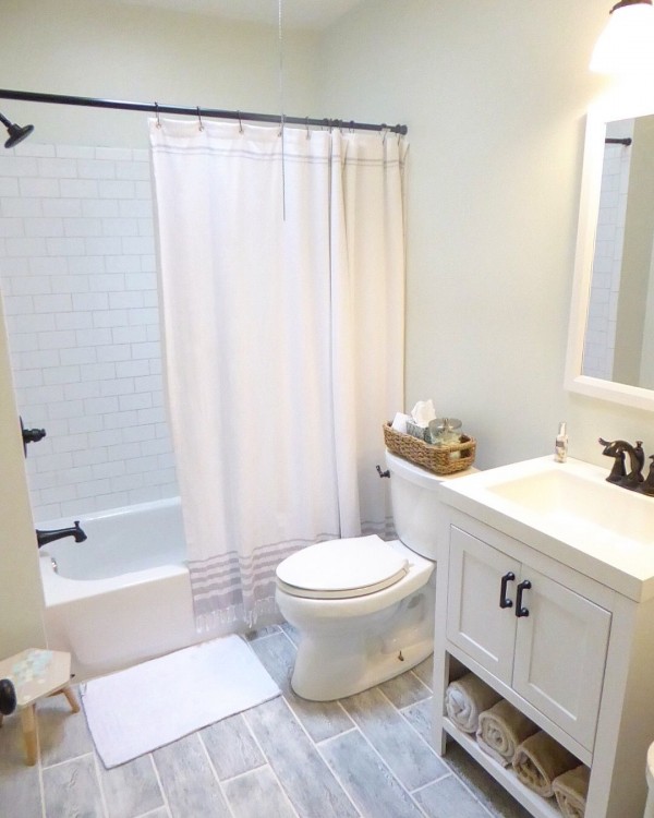 Beige tile bathtub surround with oil rubbed bronze fixtures