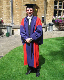 A group of graduates have their picture taken in their graduation robes