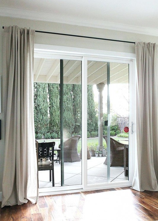 Full length grey curtains on french doors with balcony overlooking a garden