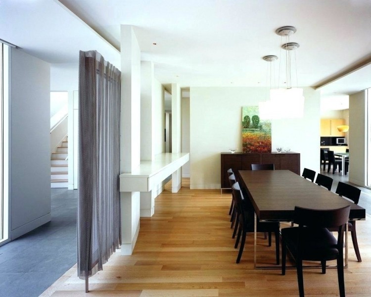 Dark wood floors match the dark oval dining table that seats six people
