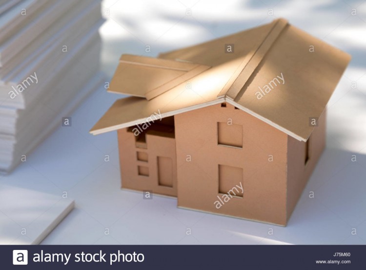 Selective focus of paper house toy or cardboard house on world map with morning sunlight